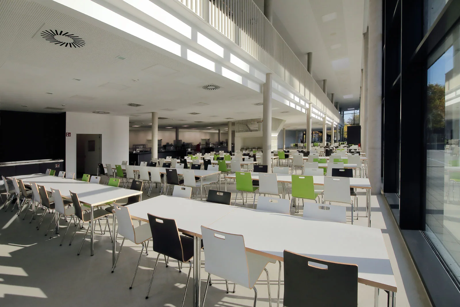 Lichtdurchflutete Mensa der Hochschule für Finanzen mit Akustikdecke und Galerie.