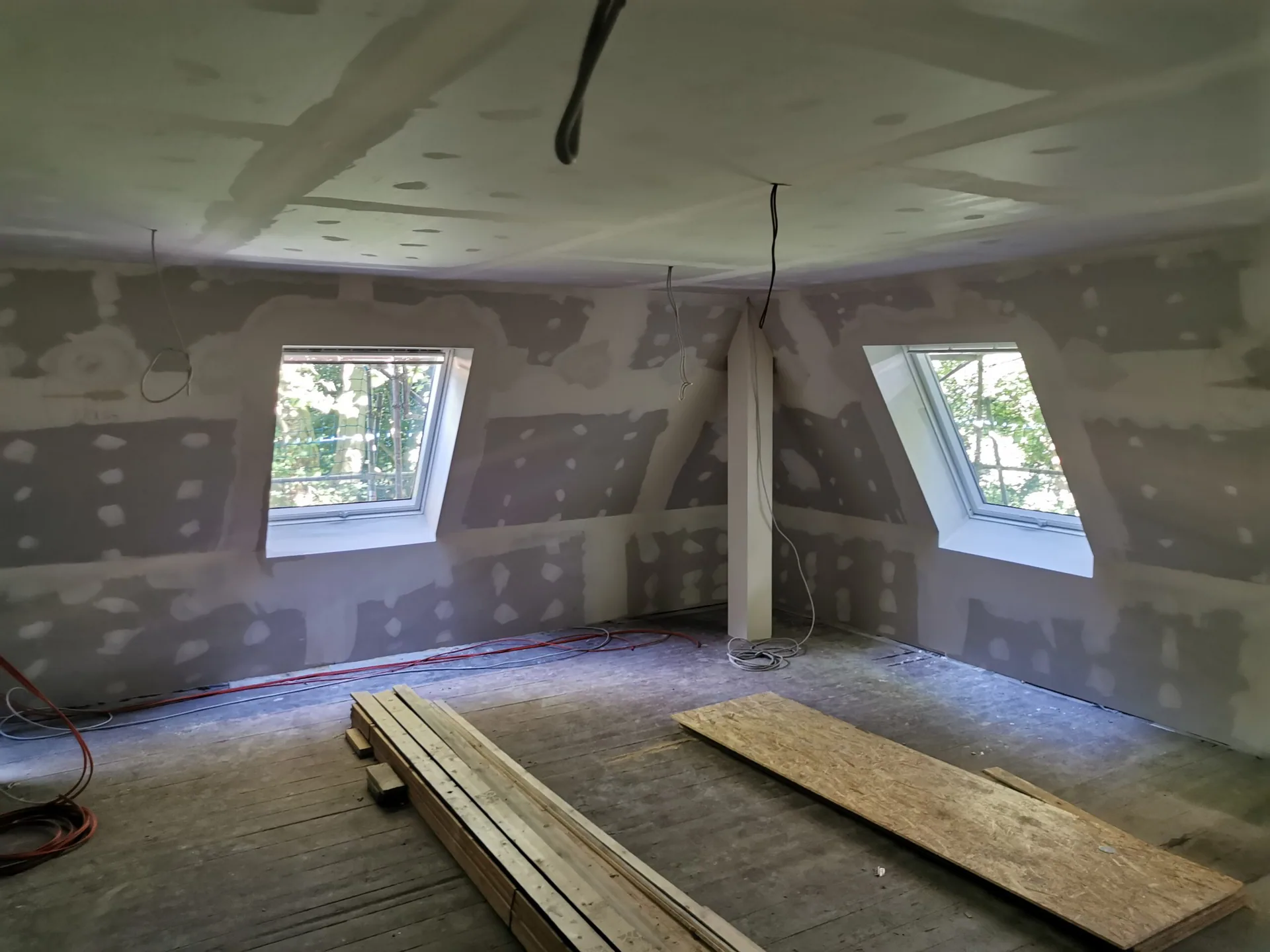 Dachraum im Haus Ludgerirast mit verspachtelten Trockenbauflächen und Baumaterial.
