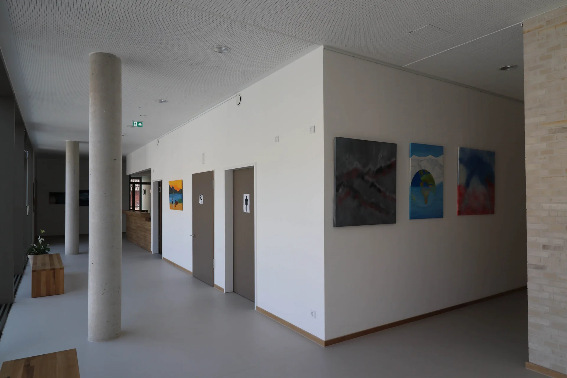 Klare Raumaufteilung mit weißen Wänden, integrierten Türen und Kunstwerken im Intergenerativen Zentrum.