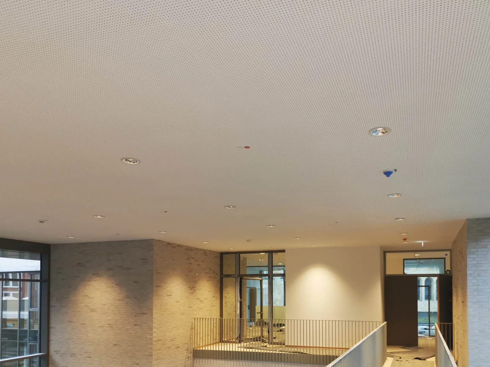Akustikdecke mit eingelassenen Leuchten über der Galerie des Intergenerativen Zentrums.